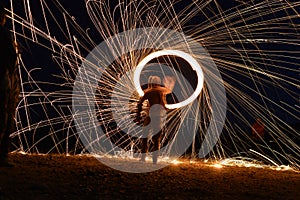 Iron wool circle drawing light fireworks. Burning Steel Wool spinning, Trajectories of burning sparks at night. Movement light eff