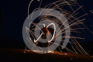 Iron wool circle drawing light fireworks. Burning Steel Wool spinning, Trajectories of burning sparks at night. Movement light eff