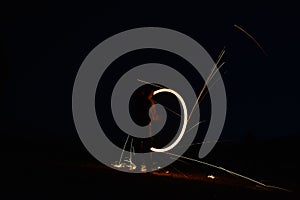 Iron wool circle drawing light fireworks. Burning Steel Wool spinning, Trajectories of burning sparks at night. Movement light eff