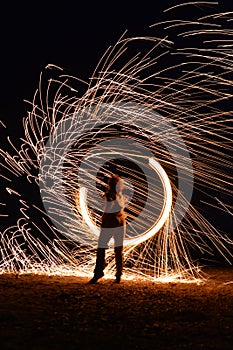 Iron wool circle drawing light fireworks. Burning Steel Wool spinning, Trajectories of burning sparks at night. Movement light eff