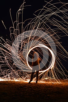 Iron wool circle drawing light fireworks. Burning Steel Wool spinning, Trajectories of burning sparks at night. Movement light eff