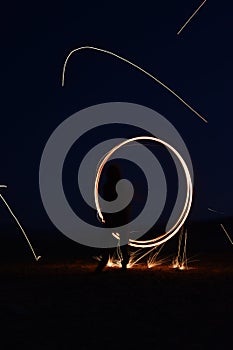 Iron wool circle drawing light fireworks. Burning Steel Wool spinning, Trajectories of burning sparks at night. Movement light eff