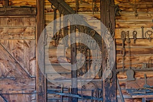 Iron working and rusted tools and chains hanging on an old wooden barn