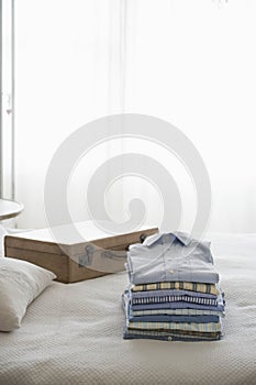 Ironed And Folded Shirts On Bed