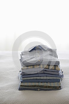 Ironed And Folded Shirts On Bed photo