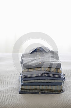 Ironed And Folded Shirts On Bed