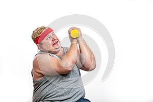 Fat funny man in red headband shows his muscles with dummbell and emotions