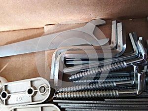 Ironmongery silver bronze iron stainless steel wrench tapping repair cardboard background macro photo photo