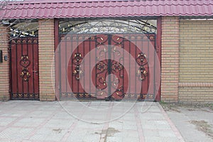 Ironwork gates and wicket with brick columns and a wall