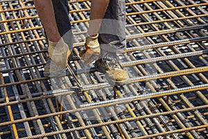 Ironworker securing steel rebar framing with wire plier cutter