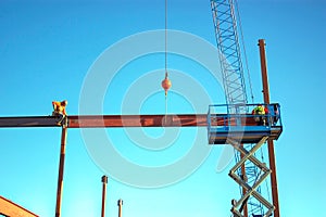 Ironworkers Fit-Up an I-Beam Suspended from Crane