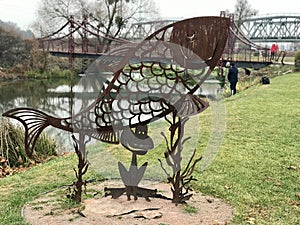 An iron fish on the boardwalk on the Irpin River Walk, photo