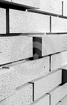 Irregular brick arrangement. On the wall. In black and white.