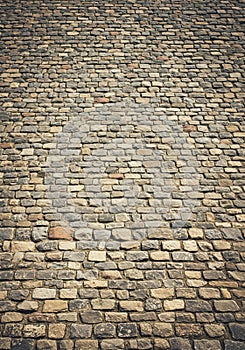 Irregular cobblestone pavement composed of variously sized stones in shades of photo