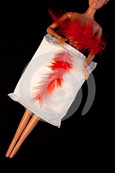 Irregular period concept. Menstrual cycle pad with red feathers on black background. Menorrhagia or heavy menstruation photo