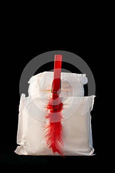 Irregular period concept. Menstrual cycle pad with red feathers on black background. Menorrhagia or heavy menstruation photo