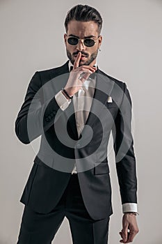 Irresistible young groom making silence gesture