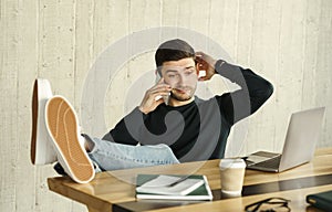 Irresponsible Freelancer Talking On Phone Delaying Deadline Sitting At Workplace photo