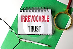 IRREVOCABLE TRUST text on notebook on green paper photo