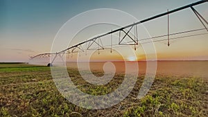 irrigate agriculture. machinery a irrigation farm field. farmer field at sunset watering plants business agricultural