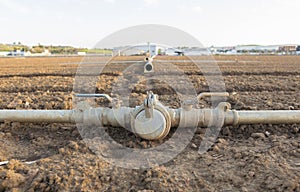 Irrigation metal pipes connections on recently seeded field