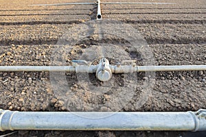 Irrigation metal pipes connections on recently seeded field