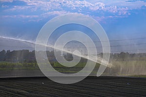 irrigation plant irrigates fields in summer photo