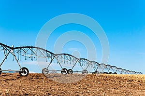 Irrigation sprinkler sits on the field after the harvest