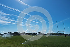 Irrigation sprinklers on a football field in a park in Florida