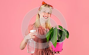 Irrigation. Watering concept. Woman with spray bottle spraying houseplants. Smiling Girl take care of flowers.