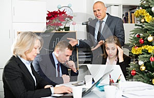 Irritated boss scolding group of stressed managers for incompetence at meeting in office