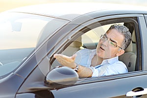 Irritated male driving car in traffic - road rage concept