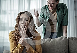 Irritated man shouting at pregnant woman