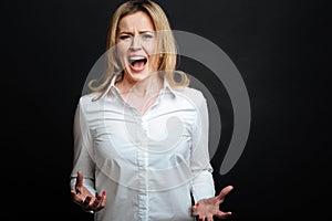 Irritated mature woman shouting in the studio