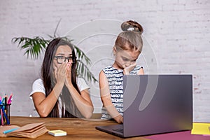 Irritated mother watching at the mistakes her daughter`s homework