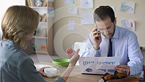 Irritated wife trying to talk with busy husband in business suit, wrangle