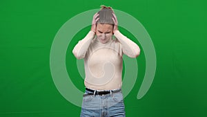 Irritated woman closing ears with hands shaking head no. Portrait of annoyed Caucasian young lady on green screen