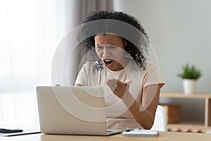 Irritated woman swears at broken or hanging out computer