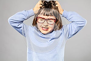 Irritated young girl pulling out hair for itchy lice allergies