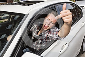 Irritated young man driving a car. Irritated driver