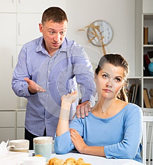 Irritated young spouses quarrelling in home kitchen interior photo