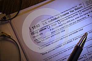 IRS blank 1040 income tax form close up with ball point pen and reading glasses