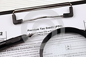 IRS Form 8962 Premium tax cerdit PTC blank on A4 tablet lies on office table with pen and magnifying glass