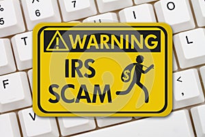 IRS scam warning sign with keyboard