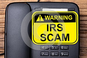 IRS Scam Warning Sign On Landline Phone