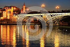 Isabel II bridge or Triana bridge over Guadalquivir river at twilight, Seville