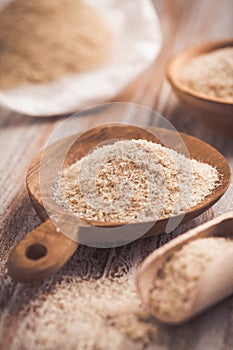 Isabgol - heap of psyllium husk in wooden bowl on wooden table table