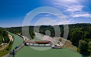 Isar river dam in southern Bavaria with fish stairs next to a beautiful forest at a beautiful day.