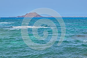 Isla de Lobos with boats in the background and the turquoise sea in Fuerteventura photo