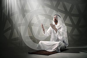 Arab muslim man having worship and praying for god blessing photo